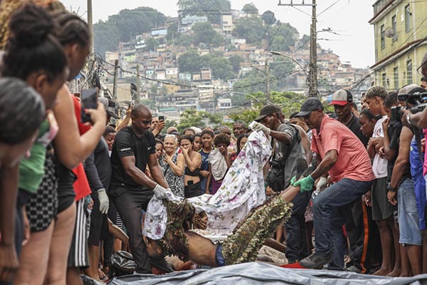 Personas acomodan cuerpos sin vida en una calle en Río de Janeiro (Brasil). EFE/ André Coelho